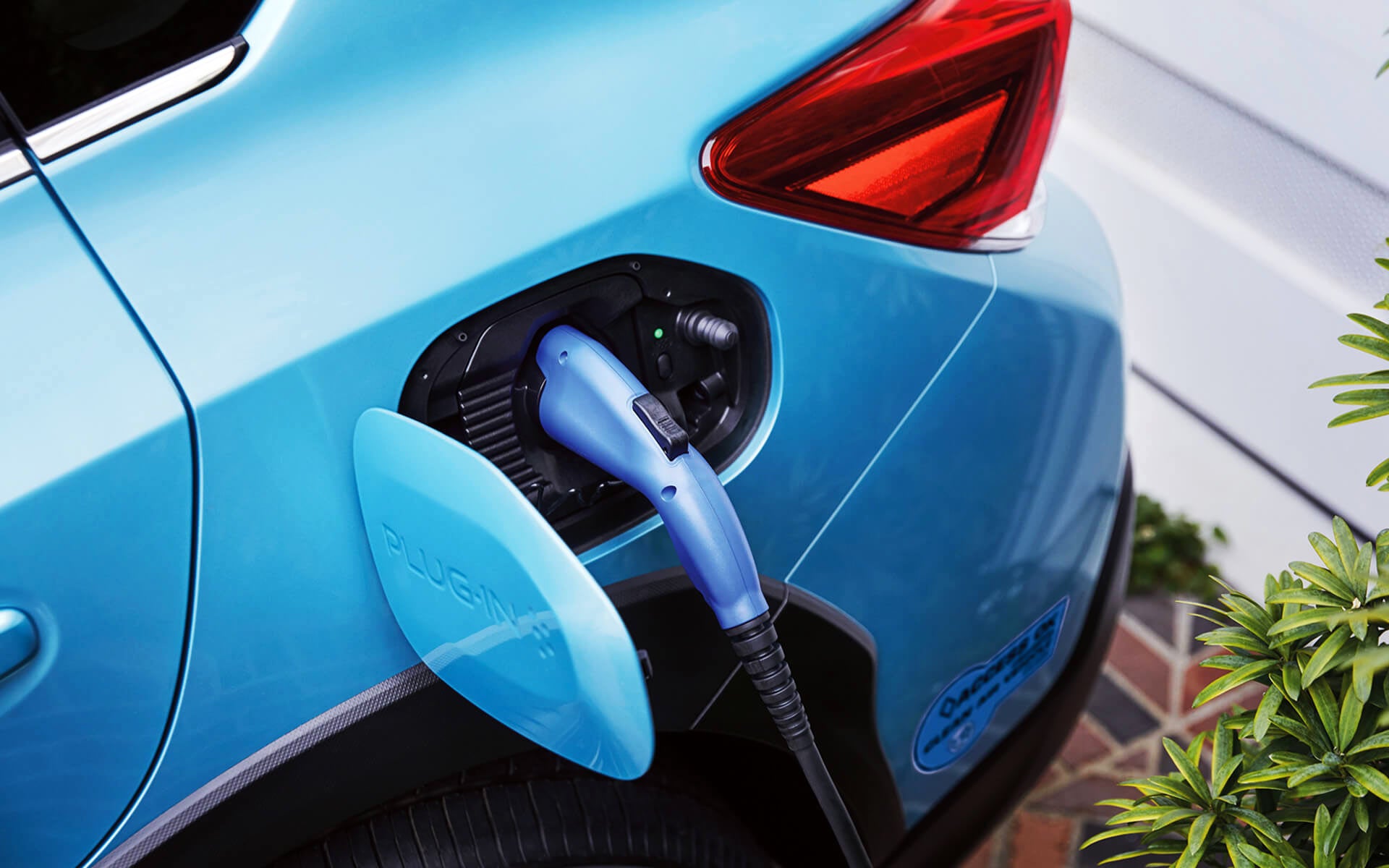 A close-up of the Subaru Crosstrek Hybrid's charging port with charging cable plugged in | Subaru World of Newton in Newton NJ