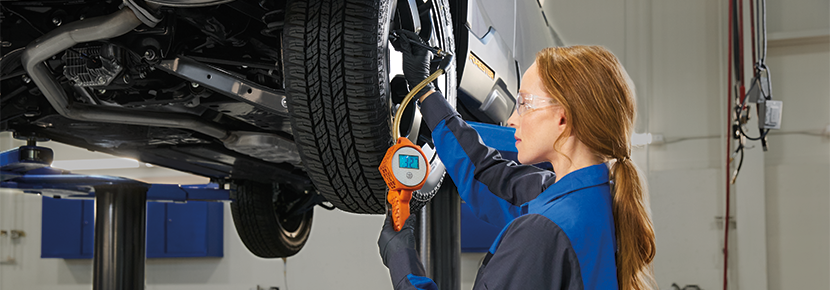 A Subaru technician checking tire pressure. | Subaru World of Newton in Newton NJ