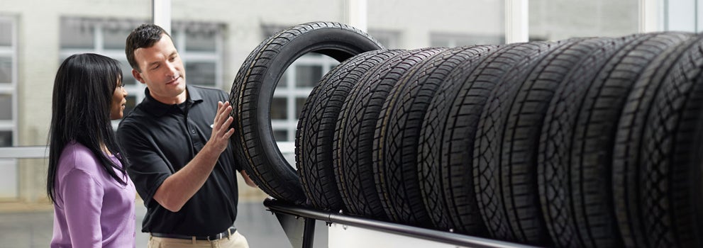 Subaru service representative showing customer a tire. | Subaru World of Newton in Newton NJ