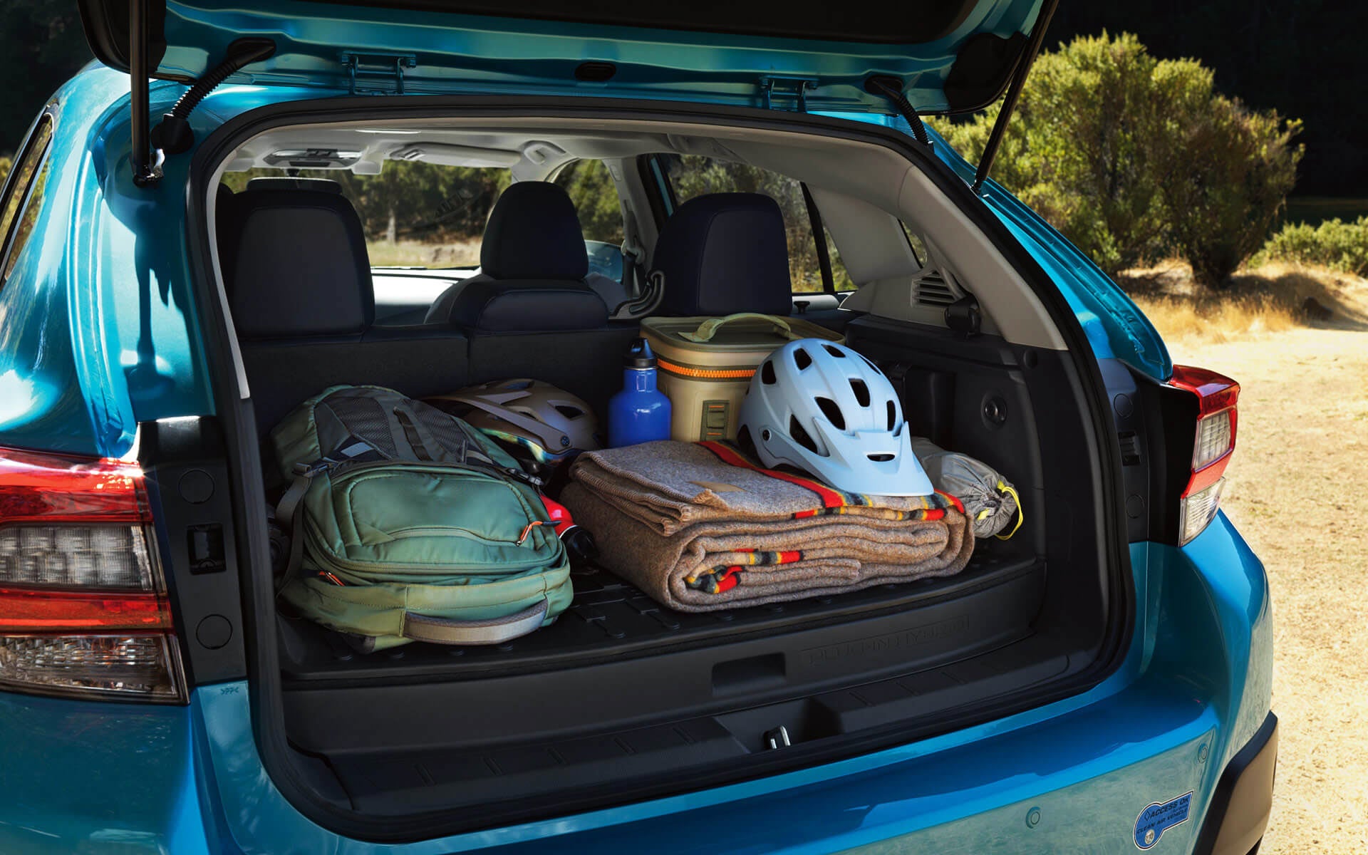 A backpack, blanket, and bike helmet in the rear cargo area of a Crosstrek Hybrid | Subaru World of Newton in Newton NJ