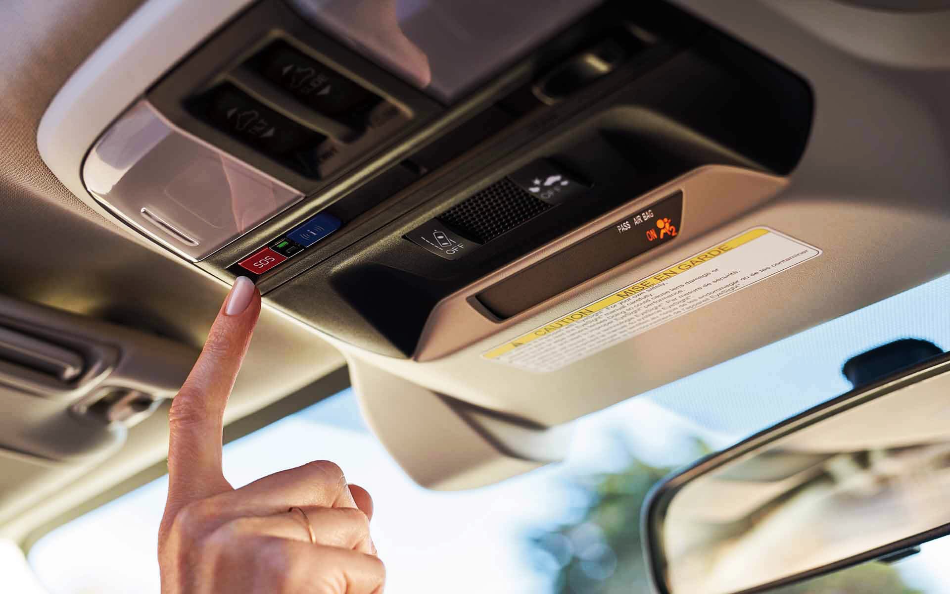 A finger pressing the Crosstrek Hybrid's SOS emergency assistance button | Subaru World of Newton in Newton NJ
